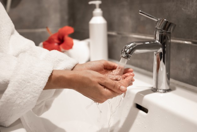 woman-robe-washes-her-hands-running-water-from-tap